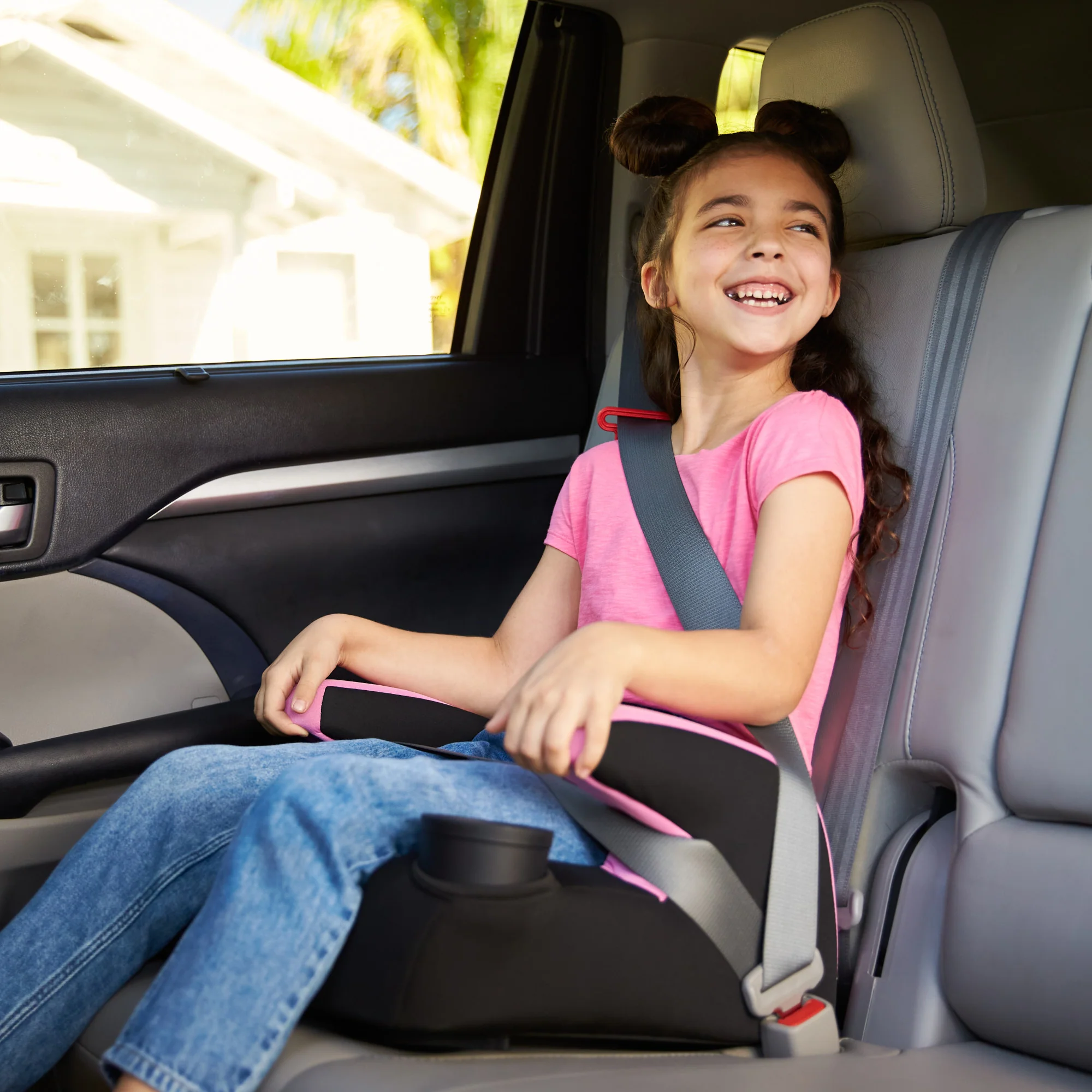 Child safely riding in a booster seat during private Orlando transportation